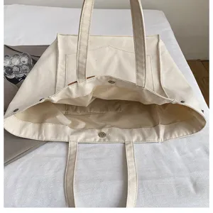 Casual canvas tote bag for women, large capacity shoulder handbag with interior pocket details.