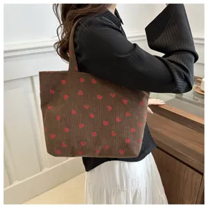 Gedetailleerd overzicht van bruine ribfluwelen tote bag met rood aardbeienpatroon.