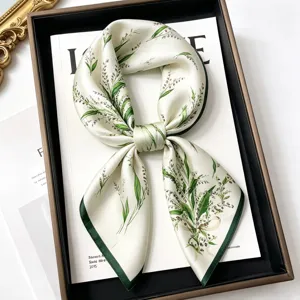 Detailed view of a luxurious mulberry silk square scarf with elegant green botanical print.