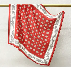 Silk square scarf detail featuring classic red and white paisley print for elegant women.
