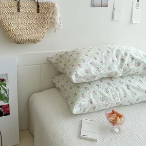 Gros plan de taie d'oreiller florale avec imprimé délicat et tissu peluche pour déco.