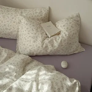 Vue détaillée de la parure de lit florale avec de belles taies d'oreiller dans la chambre.