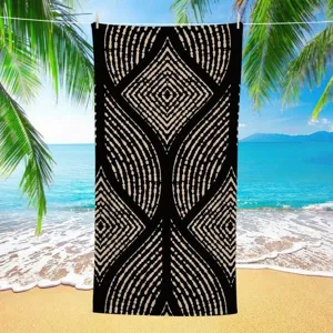 Detailed view of geometric printed beach towel with black and beige abstract tribal pattern.