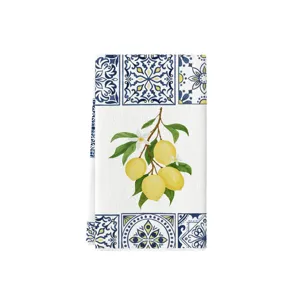 Vista dettagliata di un canovaccio da cucina con motivo a piastrelle blu e stampa di limoni freschi.