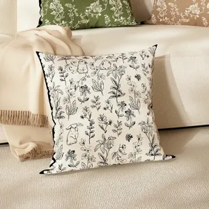 Detailed view of linen throw pillow featuring black and white floral and rabbit print.
