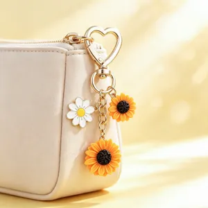 Detailaufnahme der Beigetasche mit goldenem Herz-Schlüsselbund und bunten Sonnenblumen-Anhängern.