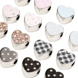 Detailed shot of electroplated silver heart beads with cute star and plaid patterns for DIY crafts.