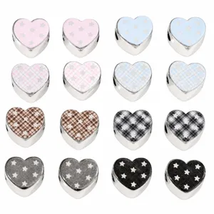 Detail view of heart shaped acrylic beads with star and plaid patterns for DIY crafts.