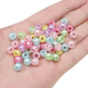 Close-up detail of colorful pastel acrylic pearl beads held in hand for craft DIY accessories.