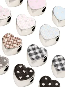 Close-up detail of acrylic silver heart loose beads with cute star patterns for DIY crafts.