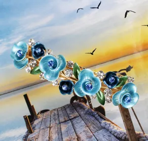 Blue floral hair clip detail showcasing delicate resin flowers and sparkling rhinestone embellishments.