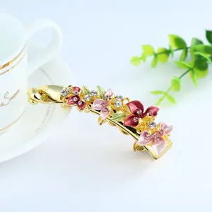 Elegant enamel floral banana hair clip, golden alloy rhinestone hair accessory for women.