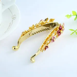 Exquisite gold alloy banana hair clip with vibrant enameled floral details and sparkling rhinestones.