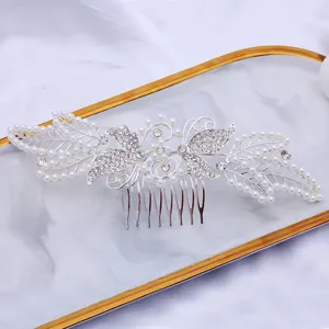 Close-up view of a silver alloy hair comb with pearls and rhinestones in a butterfly design.