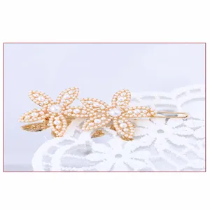 Detailaufnahme der Perlenblumen-Haarnadel mit filigranem weißem Perlendesign und goldenem Rahmen.