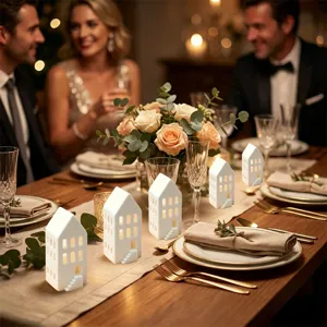 Detail van de witte keramische huisjes kandelaar op een gezellige en sfeervolle feestelijke tafel.