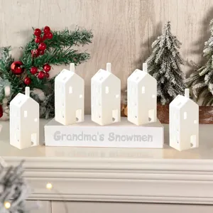 Keramische kersttheelichtjeshuisjes set met verlichte tafeldecoratie voor de feestdagen.