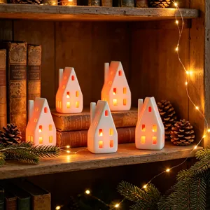 Nahaufnahme von weißen Keramik-Haus-Teelichtern mit warmem LED-Leuchten auf Holzregal.