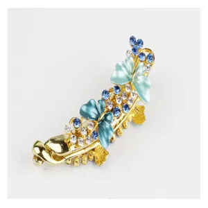 Gold tone rhinestone butterfly banana clip, elegant blue enamel hair accessory detail.
