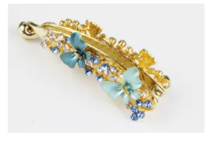 Detailed view of the gold alloy rhinestone butterfly banana hair clip with blue crystals.