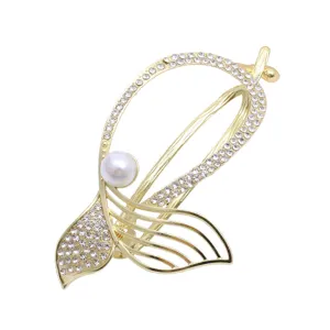 Rhinestone alloy fish tail hair clip detail, elegant gold metal bun holder with pearl.