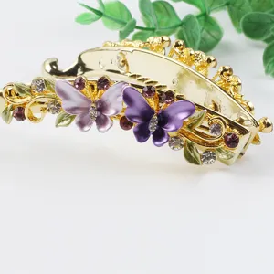 Gold metal banana hair clip featuring colorful enamel butterflies and sparkling rhinestones.