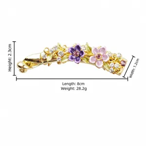 Gold tone banana hair clip with colorful enamel flowers and rhinestone details detail view