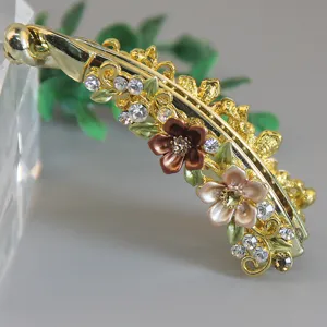 Gold-tone banana hair clip featuring sparkling rhinestones and colorful enamel floral accents.