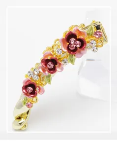 Detailed close-up view of the exquisite rhinestone enamel floral gold metal banana clip.