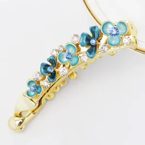 Detailed shot of Korean style floral metal banana clip with blue enamel flowers and sparkling rhinestones.