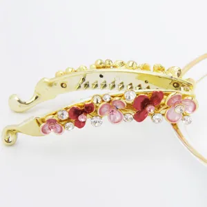 Close-up detail of the gold banana hair clip featuring colorful floral rhinestones.
