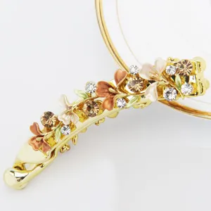 Gold metal banana hair clip with enamel flowers and sparkling rhinestones for women daily wear.