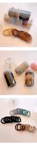 Detailed view of seamless hair ties in clear storage boxes and jars, various candy and earthy colors.