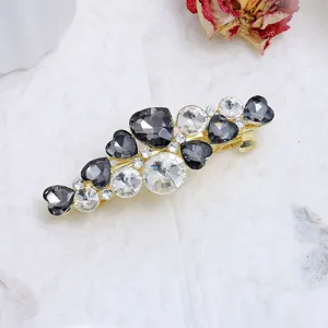Elegant rhinestone hair clip featuring heart and round crystals on a gold tone spring barrette.