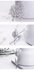 Detailed view of elegant cubic zirconia and pearl floral brooches for suits and dresses.