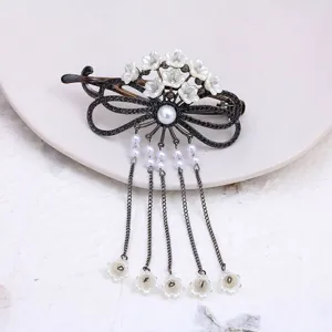 Vintage black metal hair clip with rhinestone bow, white enamel flowers and dangling tassel chains