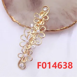 Detailed view of the gold floral hair clip featuring sparkling rhinestones and pearl accents.