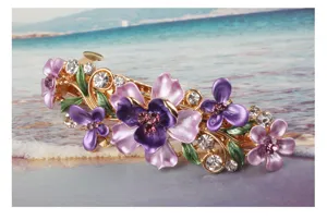 Close-up detail of a colorful enamel flower and rhinestone hair clip with alloy spring design.
