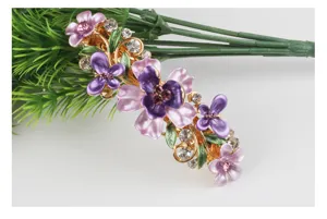 Detailed close-up view of alloy enamel flower hair clip with shiny rhinestones.