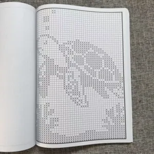 Vue detaillee d'une page de livre de motifs de point de croix avec des symboles de grille clairs.