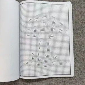 Détail de livre de modèles de point de croix affichant des grilles et des motifs pixel.
