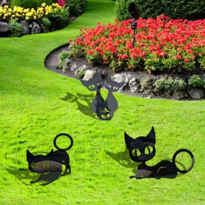 Close-up of black cat acrylic yard art silhouettes reflecting garden scenery on green grass.