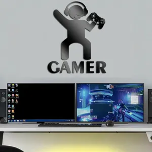 Detailed view of acrylic gamer wall sticker mounted above desk setup with monitors and speakers.