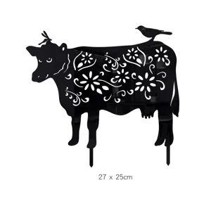 Black acrylic cow yard art detail showing hollow floral silhouette and bird design on stake.