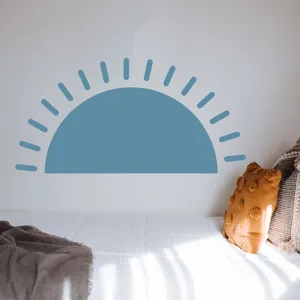 Dettaglio adesivo murale Boho mezzaluna con design sole blu in una camera da letto accogliente.