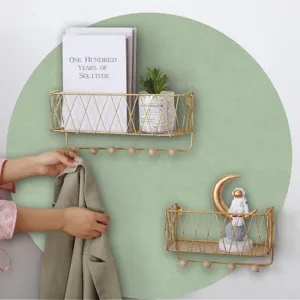 Modern gold wire wall shelf with wooden hooks, floating storage rack for home decor.