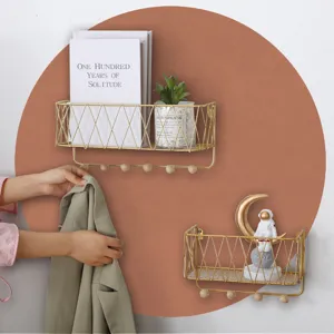 Wall-mounted gold wire storage shelf detail showing hook functionality and decorative display.