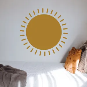 Boho sun wall sticker detail in bedroom setting, cozy warm yellow home decor accent.