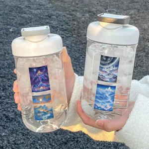 Detail view of transparent plastic water bottles with fantasy mountain art and scale lines.