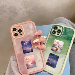 A close-up shot showcasing aesthetic landscape patterned phone cases held in hand with style.